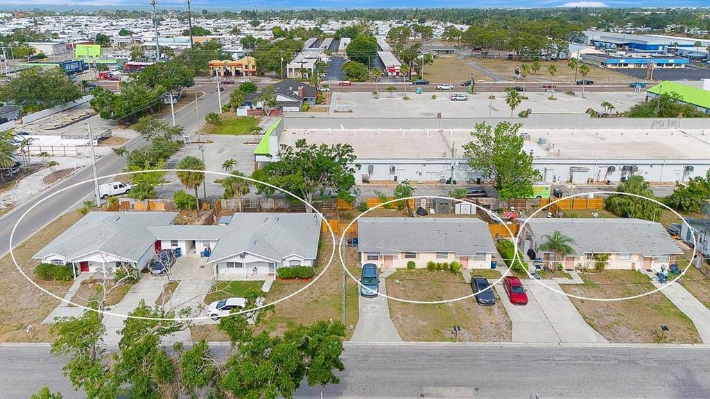 An aerial view shows three adjacent residential buildings with gray roofs and concrete driveways — 6528/ 6530 12TH STREET W, BRADENTON, FL