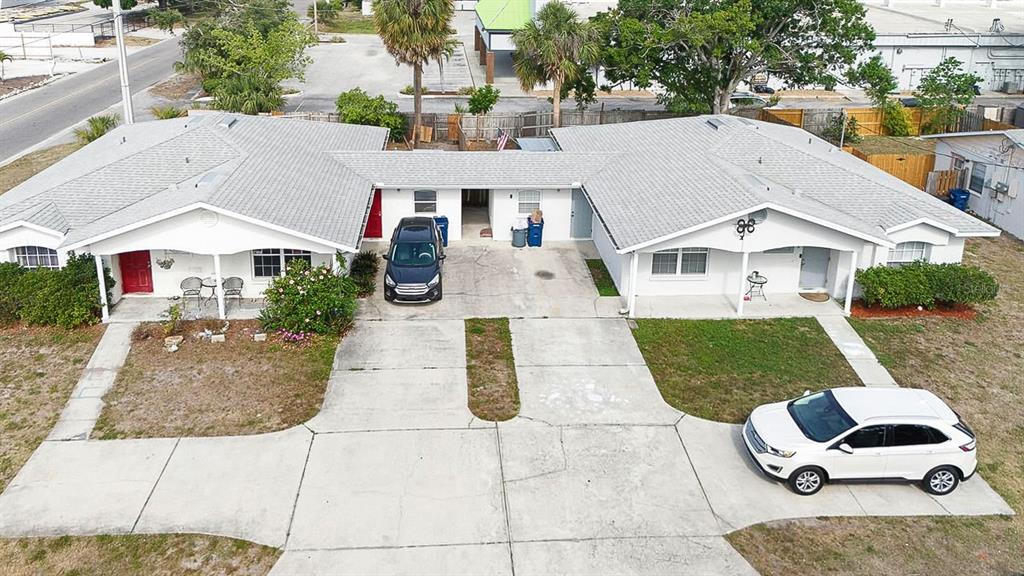 An aerial view shows a single-story duplex with two cars parked in the concrete driveway — 6528/ 6530 12TH STREET W, BRADENTON, FL