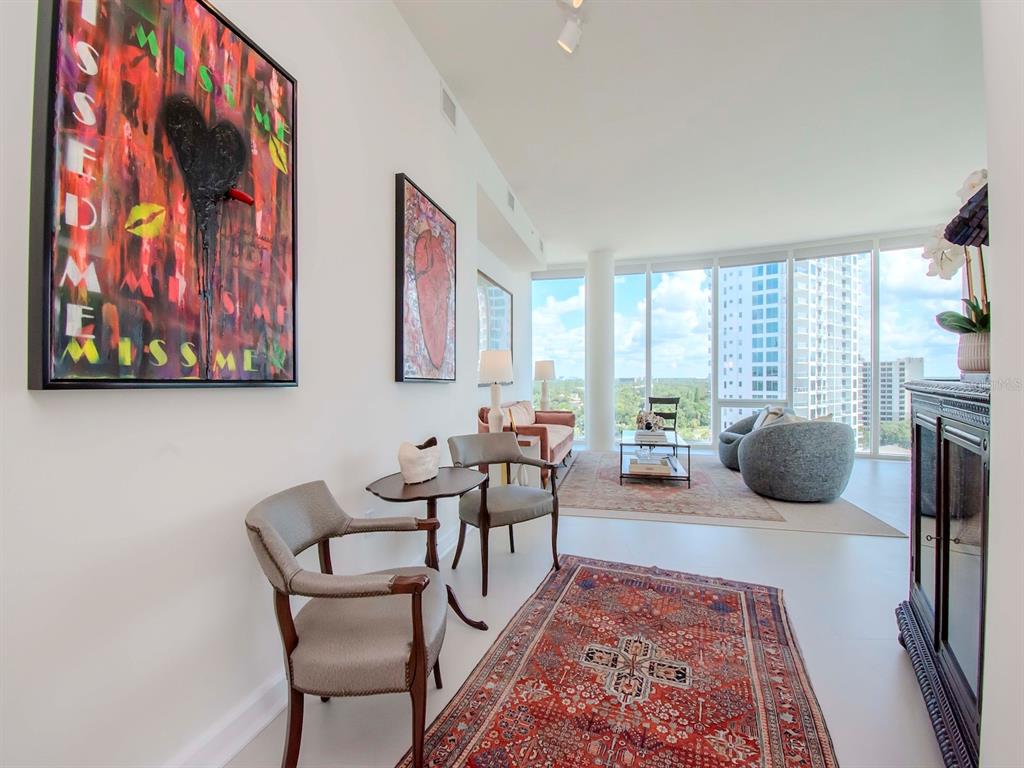 A bright living area features modern art, two area rugs, and floor-to-ceiling windows with views — 2900 W BAY TO BAY BOULEVARD UNIT 1203, TAMPA, FL