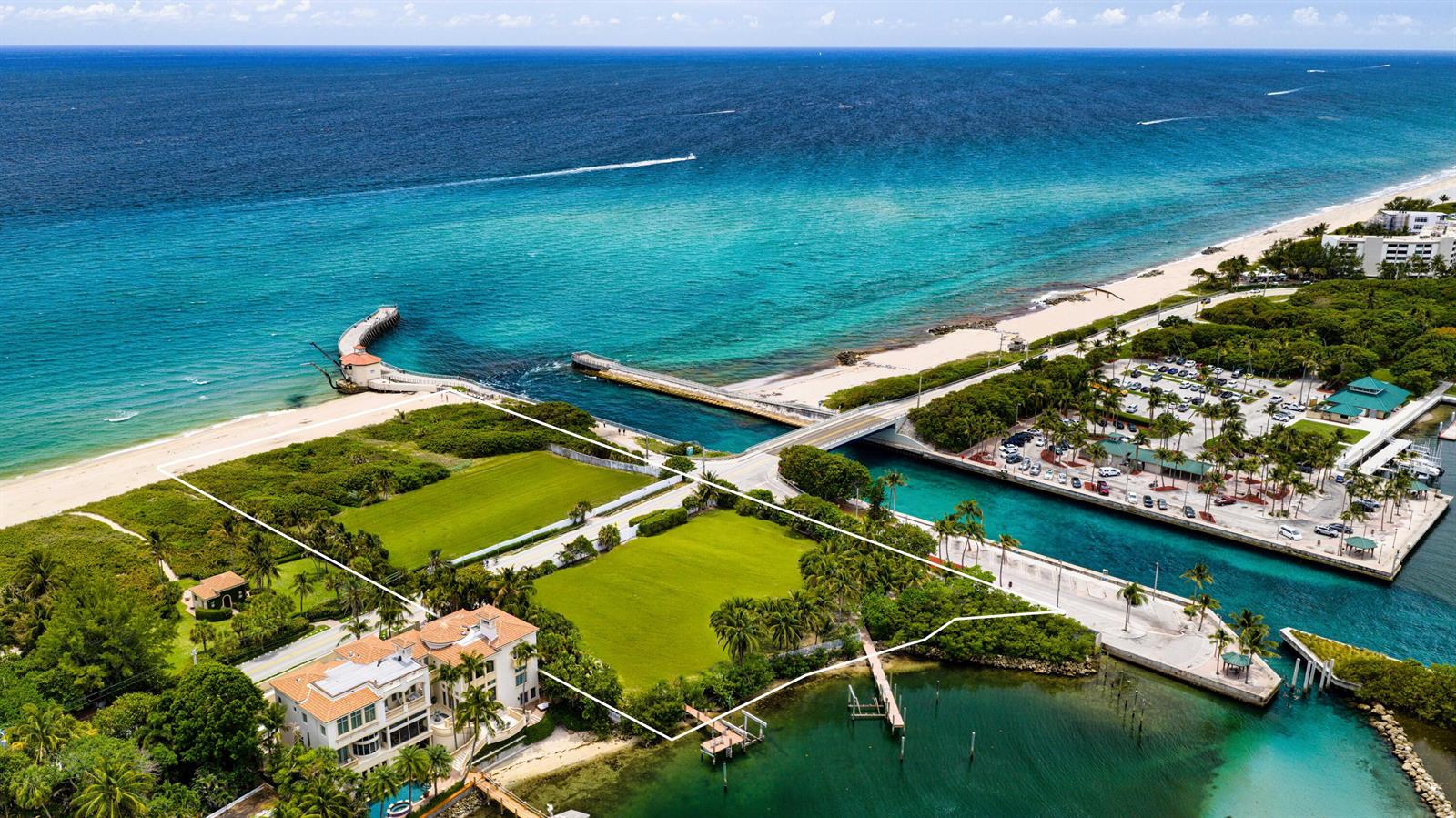 An aerial view shows a waterfront property with a large house, green lawns, and docks — 4000 S Ocean Boulevard, Manalapan FL 33462, MANALAPAN, FL