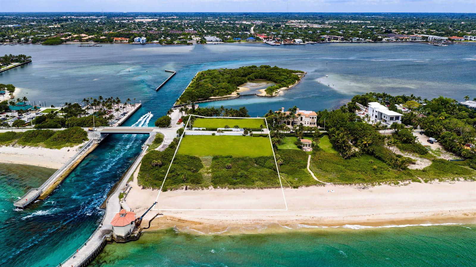 An aerial view shows a vacant beachfront lot outlined in white next to a canal — 4000 S Ocean Boulevard, Manalapan FL 33462, MANALAPAN, FL