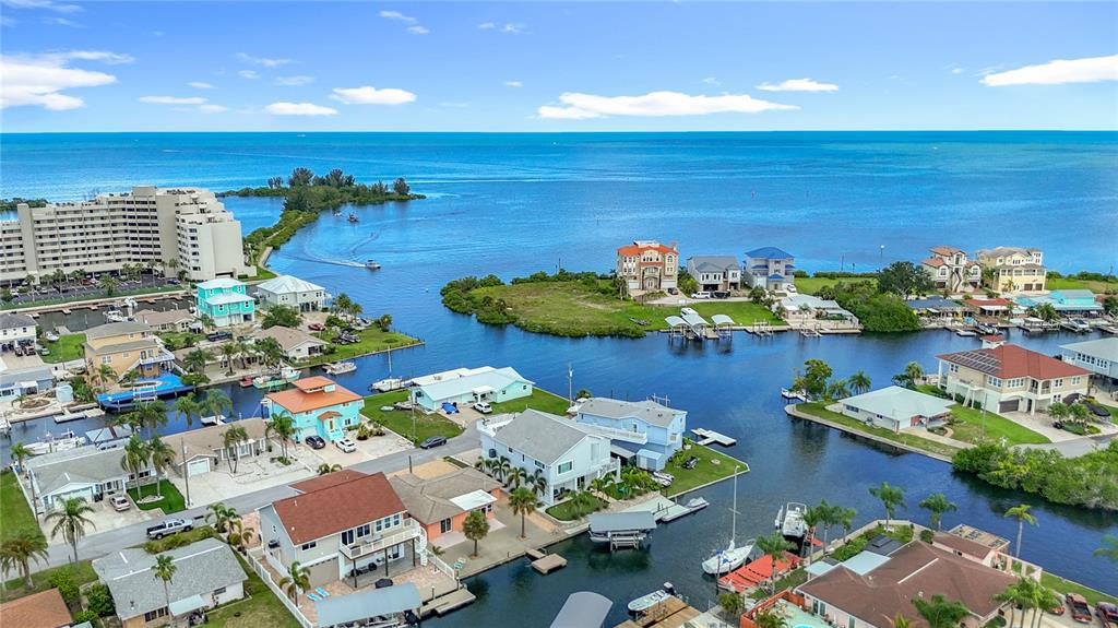An aerial view shows waterfront houses with boat docks along a canal near the ocean — 13816 VICTOR AVENUE, HUDSON, FL