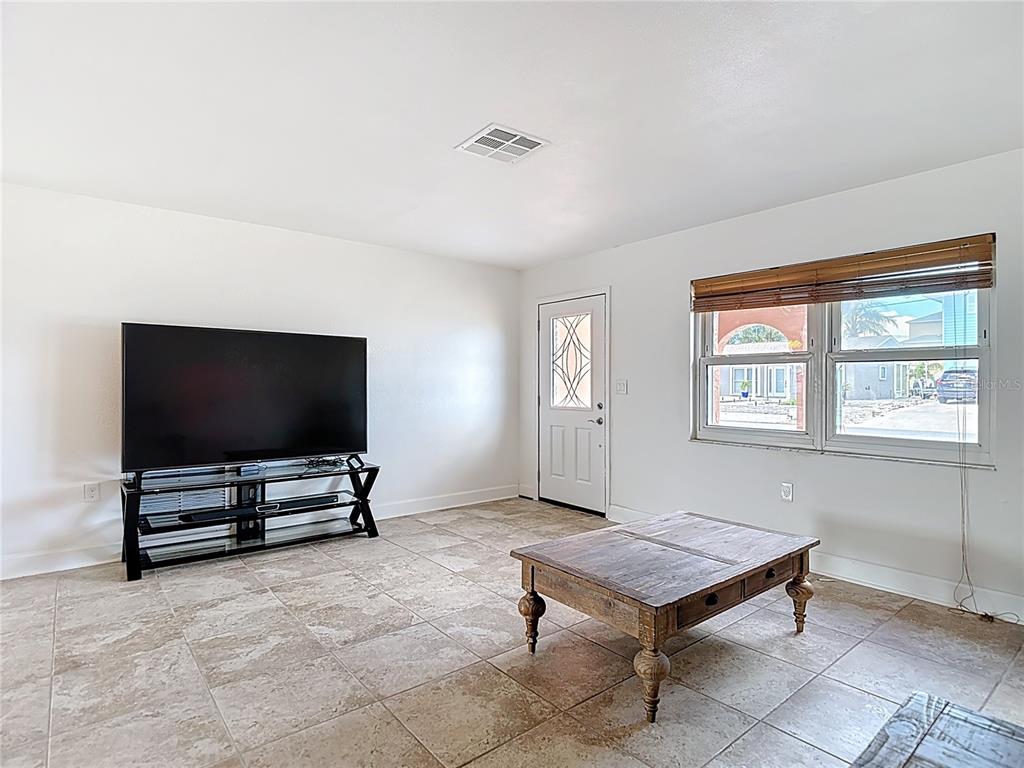 A living room features white walls, tile flooring, a television on a stand, and a coffee table — 13816 VICTOR AVENUE, HUDSON, FL