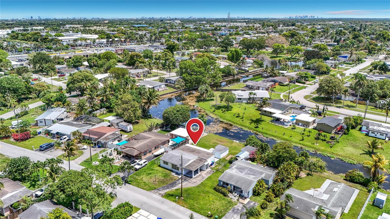 An aerial view shows a residential neighborhood with a canal and a marked house — 5930 NW 24th Ct, Margate FL 33063, MARGATE, FL