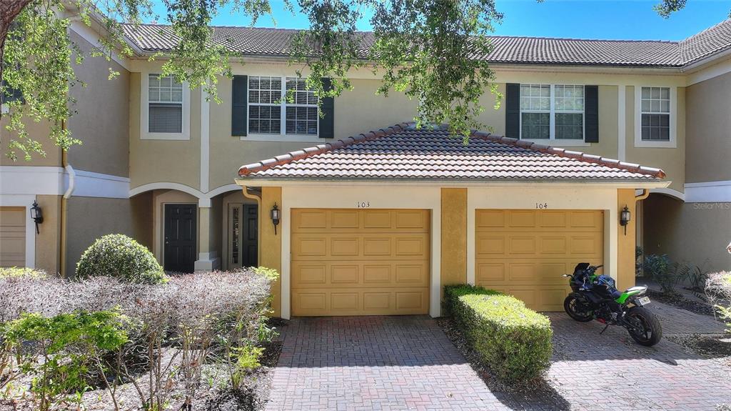An aerial view shows a residential complex situated along a large lake near Universal Studios — 6342 DAYSBROOK DRIVE UNIT 103, ORLANDO, FL