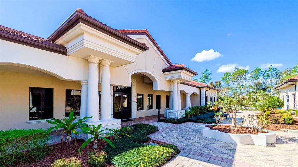 The exterior of a beige commercial building features white columns and a tiled roof — 8946 77TH TERRACE E, LAKEWOOD RANCH, FL
