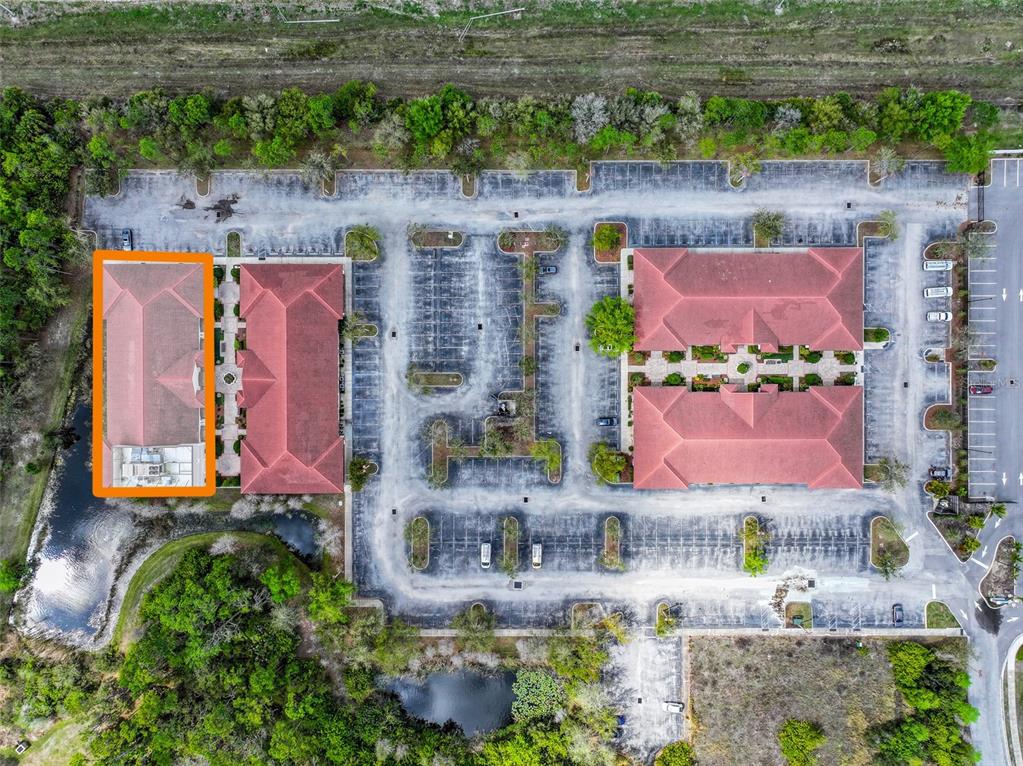 An aerial view shows two commercial buildings with red tile roofs surrounded by parking lots — 8946 77TH TERRACE E, LAKEWOOD RANCH, FL