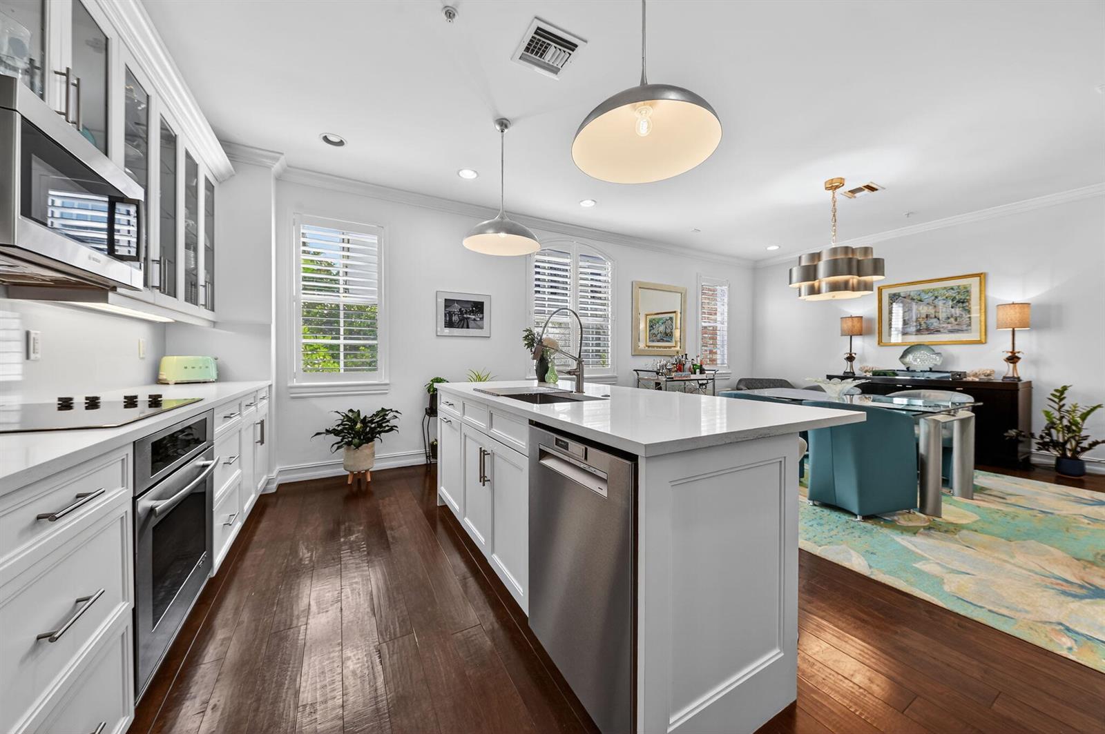A white kitchen with a center island, stainless steel appliances, and dark hardwood floors — 145 N Cannery Row Circle, Delray Beach FL 33444, DELRAY BEACH, FL