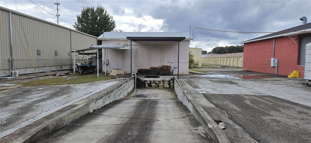 An exterior view shows a concrete loading dock ramp between a metal building and a warehouse — 3250 DUNDEE ROAD, WINTER HAVEN, FL