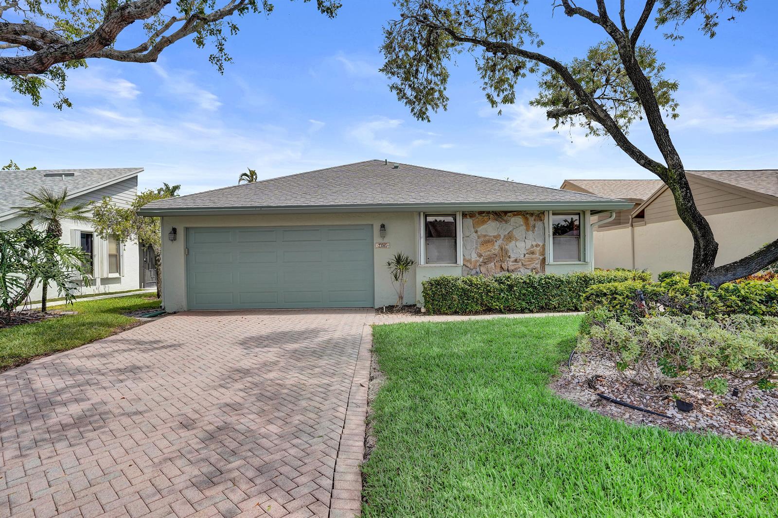 A single-story house with a paved driveway, stone facade, and a two-car garage — 2395 NW 15th Street, Delray Beach FL 33445, DELRAY BEACH, FL