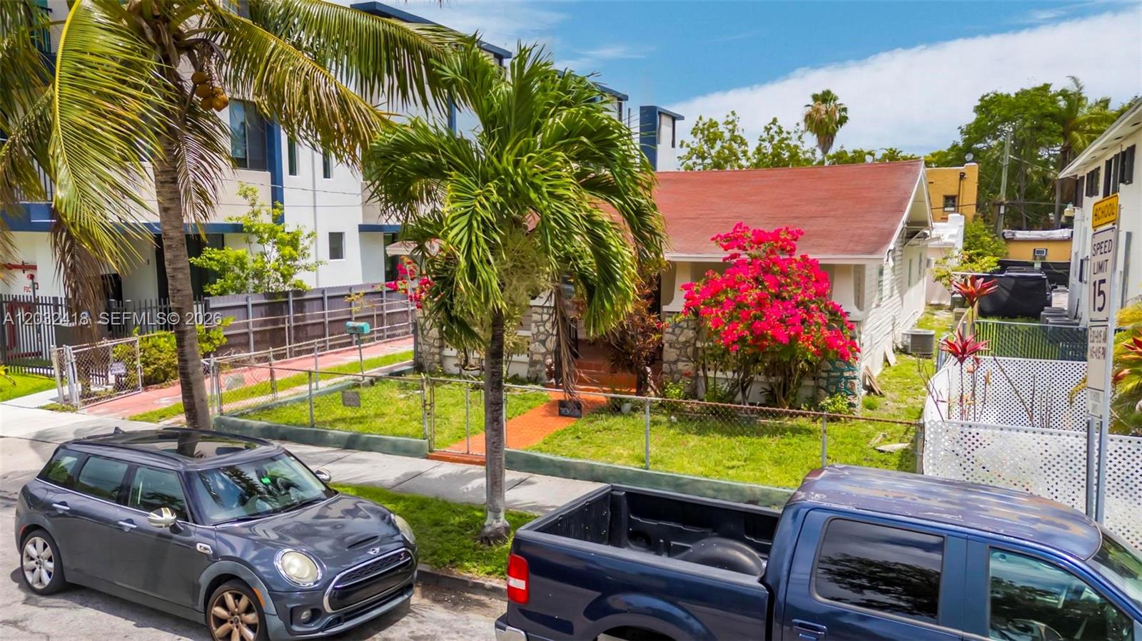 A small house with a red roof and bright pink bougainvillea sits behind a fence — 1243 SW 3rd St # 1, Miami FL 33135, MIAMI, FL