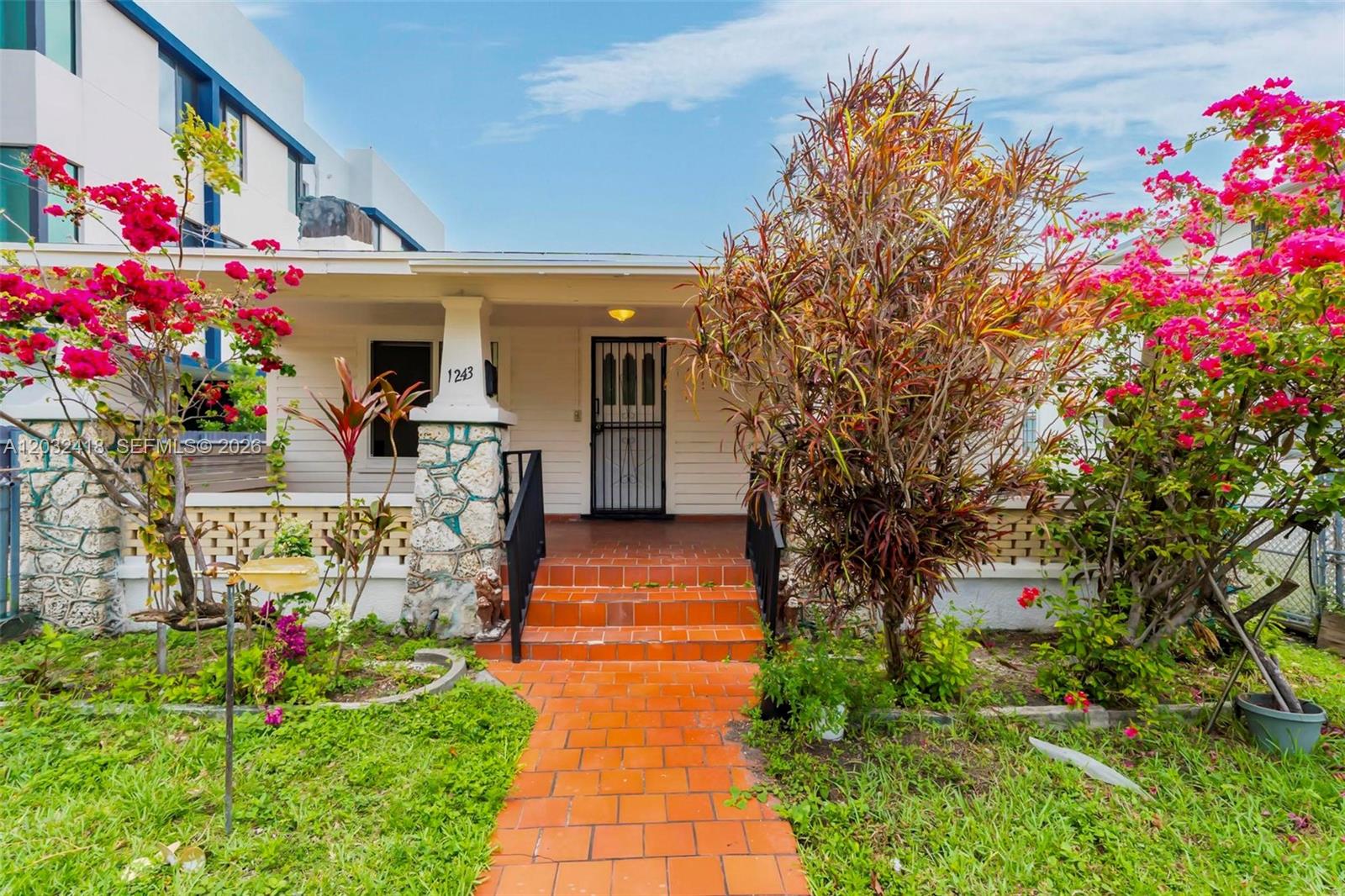 A single-story house features a stone-based porch, terracotta steps, and vibrant bougainvillea bushes — 1243 SW 3rd St # 1, Miami FL 33135, MIAMI, FL