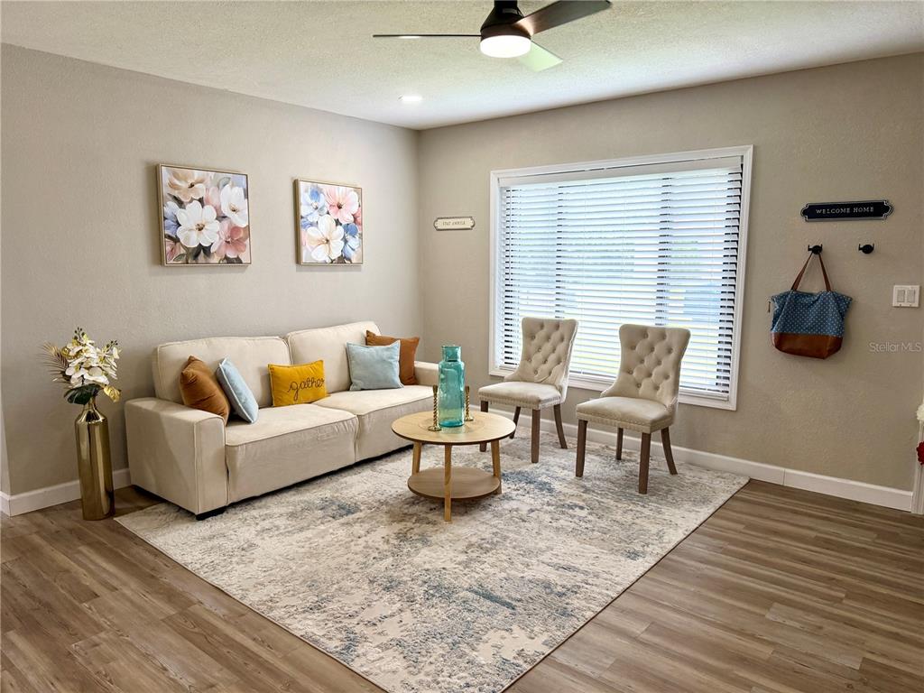 A living room features a beige sofa, two tufted chairs, and a patterned area rug — 6612 SIERRA TERRACE, NEW PORT RICHEY, FL