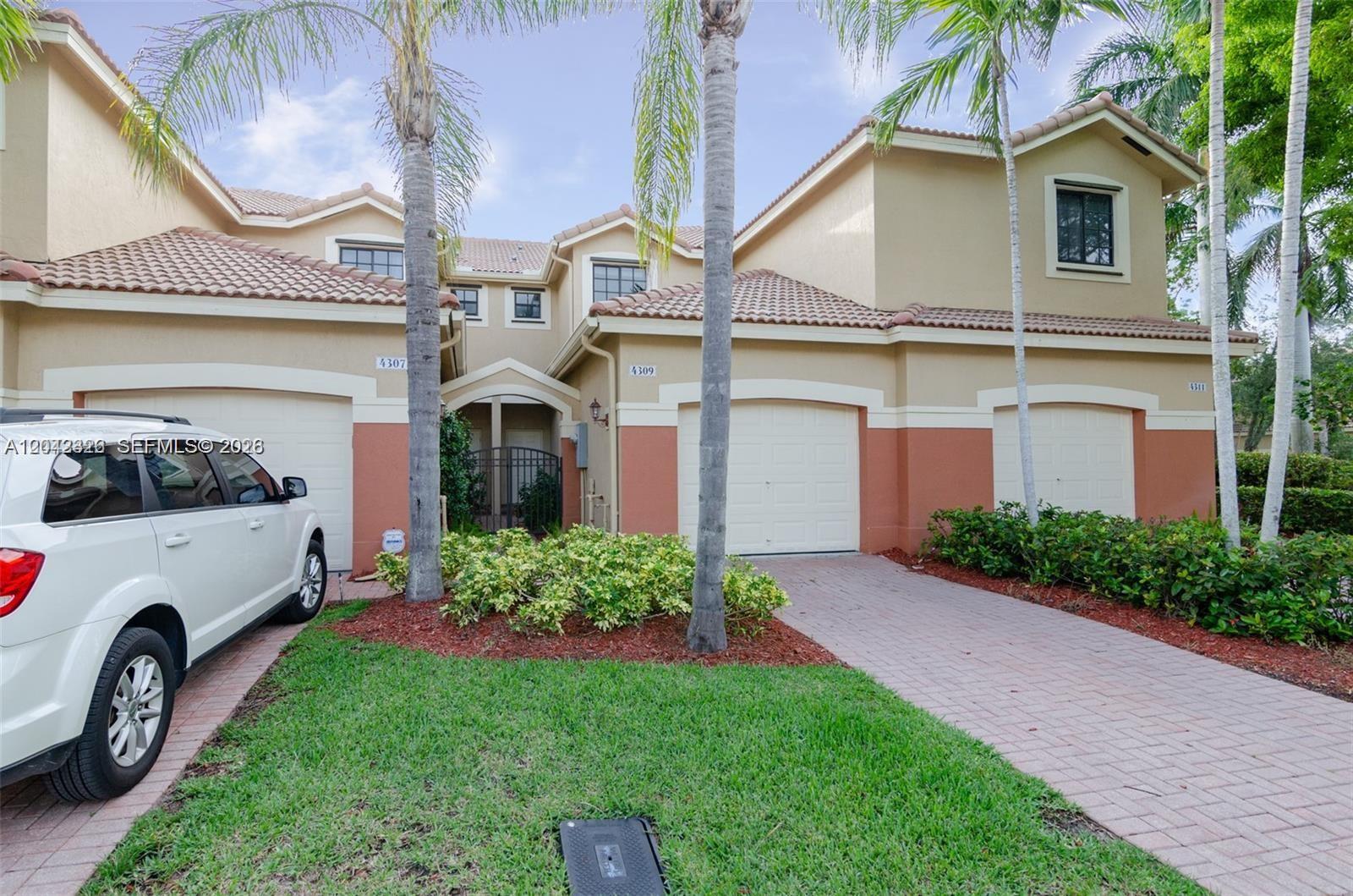 A two-story residential building features a paved driveway, a white SUV, and palm trees — 4309 Vineyard Cir # 4309, Weston FL 33332, WESTON, FL