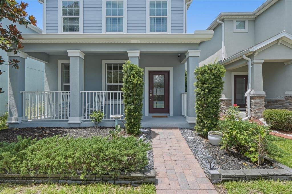 A front view of a two-story house with a covered porch and brick walkway — 11822 PHILOSOPHY WAY, ORLANDO, FL