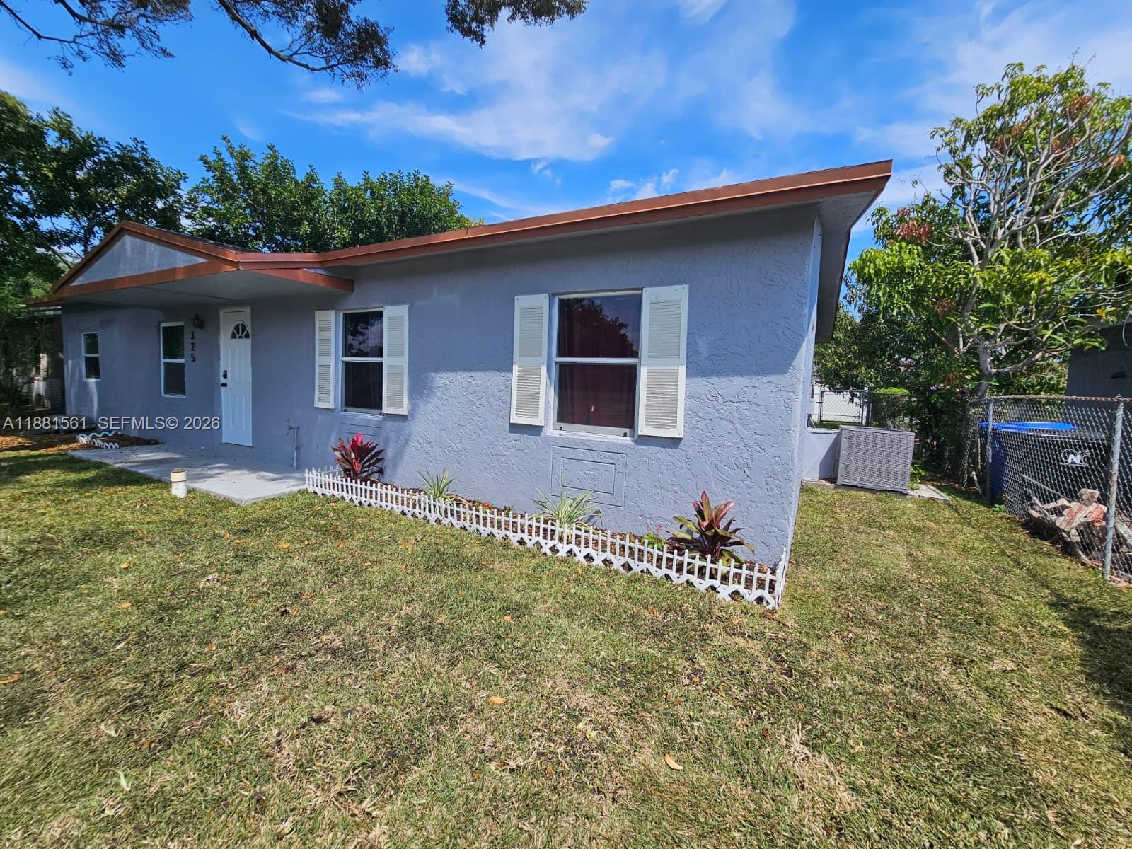 A single-story gray house features a brown roof, white shutters, and a small front yard — 325 SW 80th Ter, North Lauderdale FL 33068, NORTH LAUDERDALE, FL