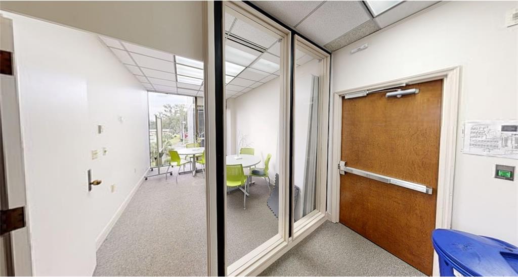 A view of an office interior with a glass-walled conference room and a wooden door — 2815 NW 13TH STREET 2nd Floor, GAINESVILLE, FL