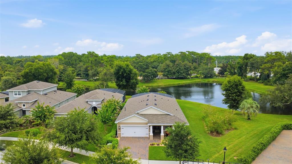 An aerial view shows a suburban house with a paved driveway and a backyard pond — 253 OLD MOSS CIRCLE, DELAND, FL
