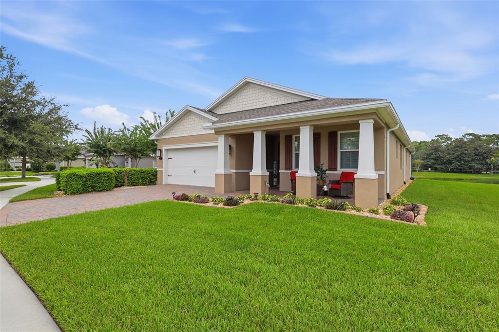 A single-story house with a tan exterior, a two-car garage, and a covered front porch — 253 OLD MOSS CIRCLE, DELAND, FL