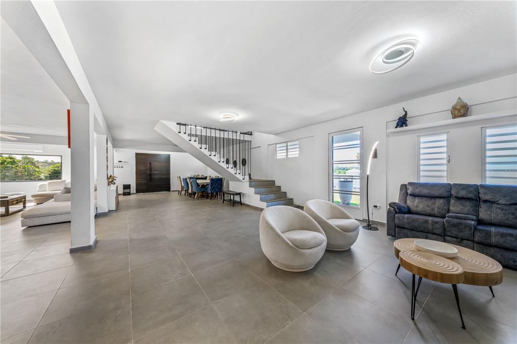 A spacious living room features large gray floor tiles, a staircase, and modern furniture — 1 PINAR DEL MAR STREET, CAMUY, PR