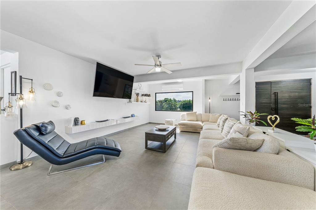 A modern living room features a large sectional sofa, a lounge chair, and a television — 1 PINAR DEL MAR STREET, CAMUY, PR