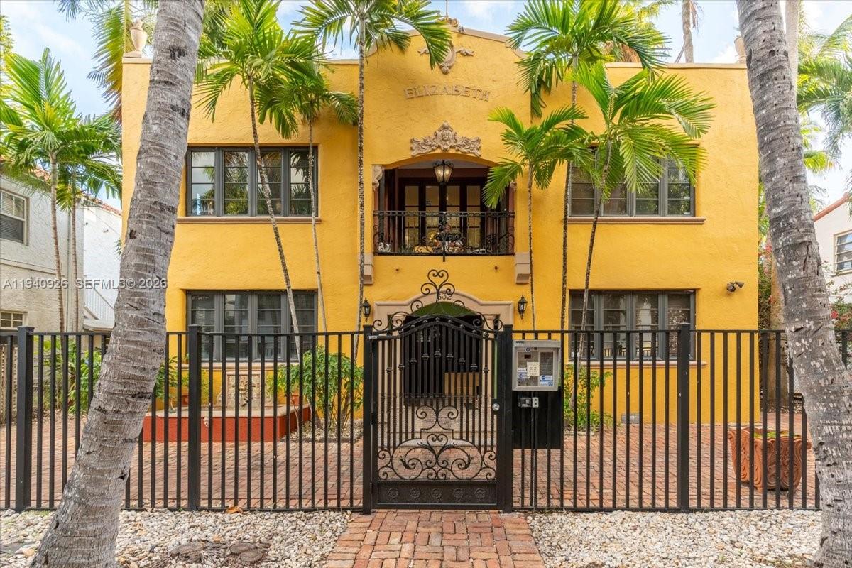 The exterior of a yellow two-story building features a central balcony and black metal fencing — 632 15th St, Miami Beach FL 33139, MIAMI BEACH, FL