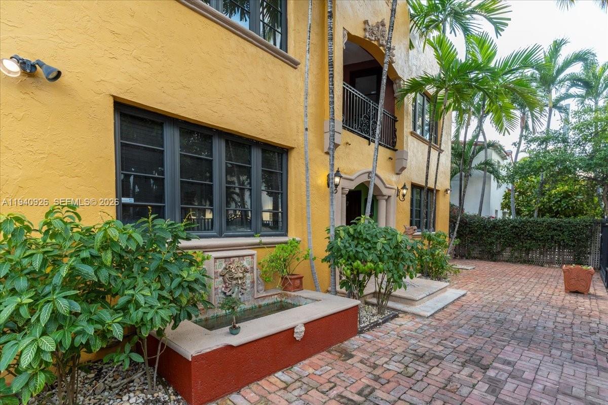 A yellow stucco building features a small stone fountain and a brick-paved courtyard — 632 15th St, Miami Beach FL 33139, MIAMI BEACH, FL