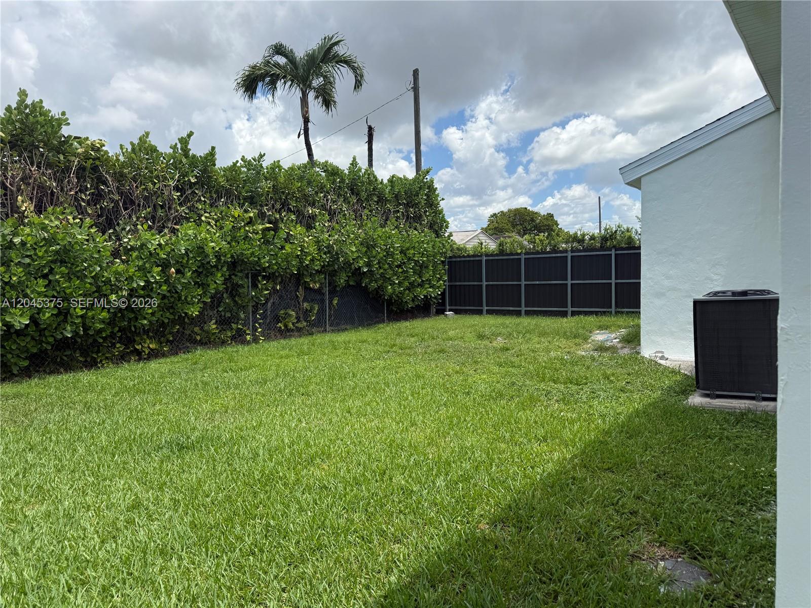 A grassy backyard features a chain-link fence, a privacy fence, and a palm tree — 3500 SW 87th Pl # 3500, Miami FL 33165, MIAMI, FL