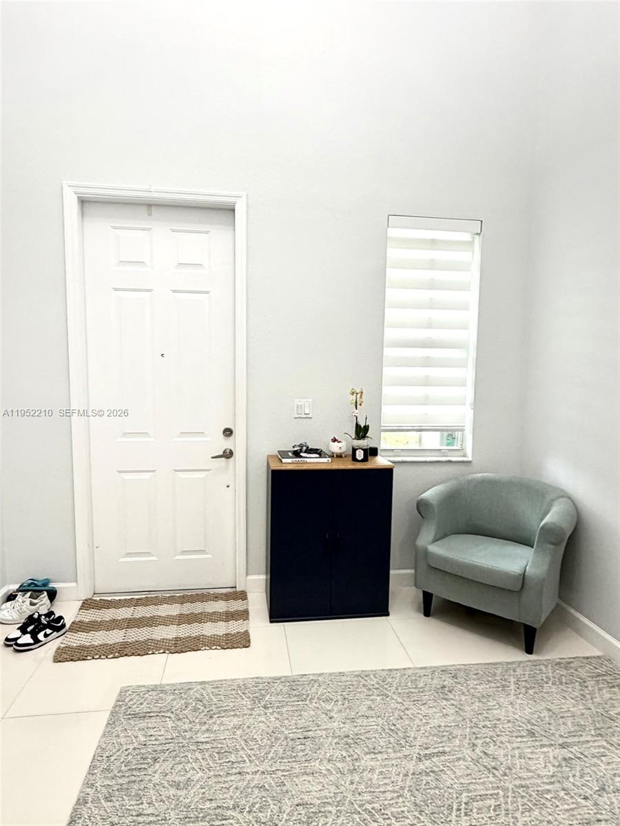 An entryway features a white door, a dark cabinet, a light blue chair, and tile flooring — 10780 NW 74th Ln, Doral FL 33178, DORAL, FL