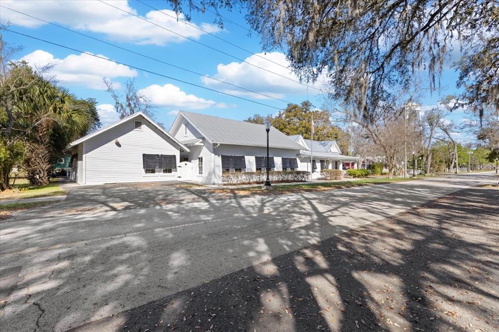 A light-colored, single-story building with a metal roof sits beside a paved road — 115 NW 1ST STREET, TRENTON, FL