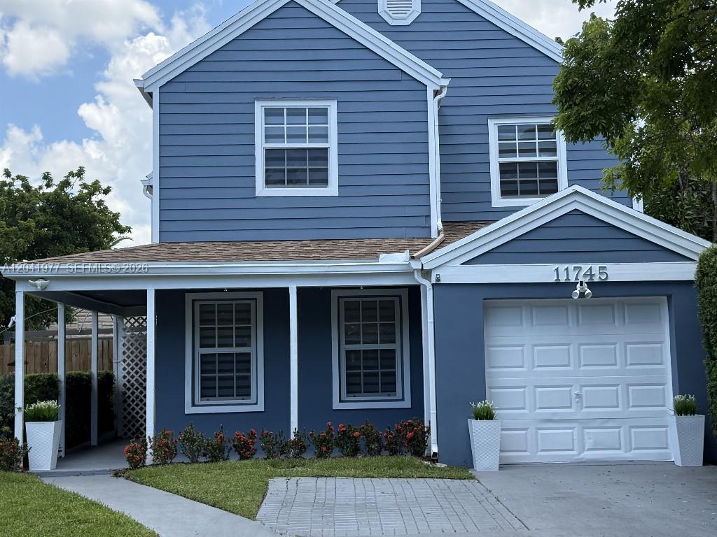A two-story blue house with a white garage door and a covered front porch — 11745 SW 116th Ter, Miami FL 33186, MIAMI, FL