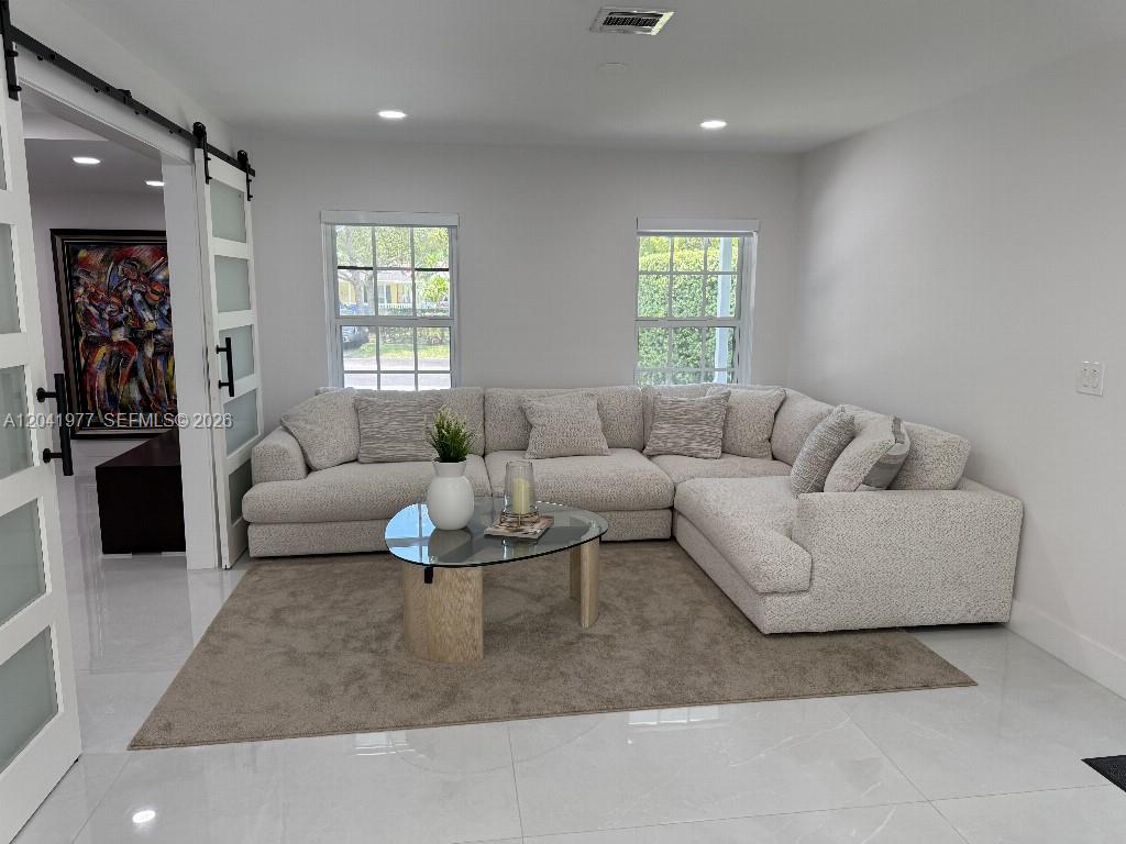 A living room features a large sectional sofa, a glass coffee table, and a sliding door — 11745 SW 116th Ter, Miami FL 33186, MIAMI, FL