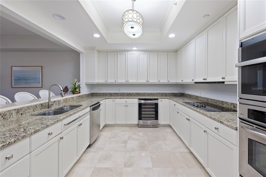 A kitchen features white cabinets, granite countertops, stainless steel appliances, and a central pendant light — 300 BEACH DRIVE NE UNIT 302, ST PETERSBURG, FL