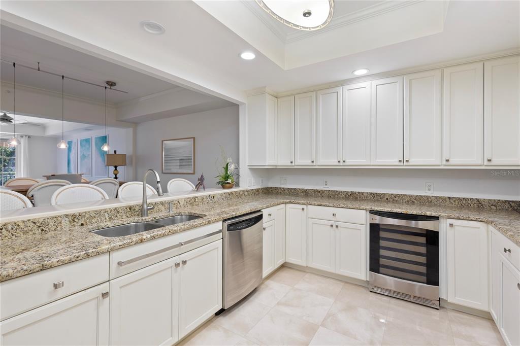 A kitchen features white cabinets, granite countertops, a stainless steel dishwasher, and a wine cooler — 300 BEACH DRIVE NE UNIT 302, ST PETERSBURG, FL