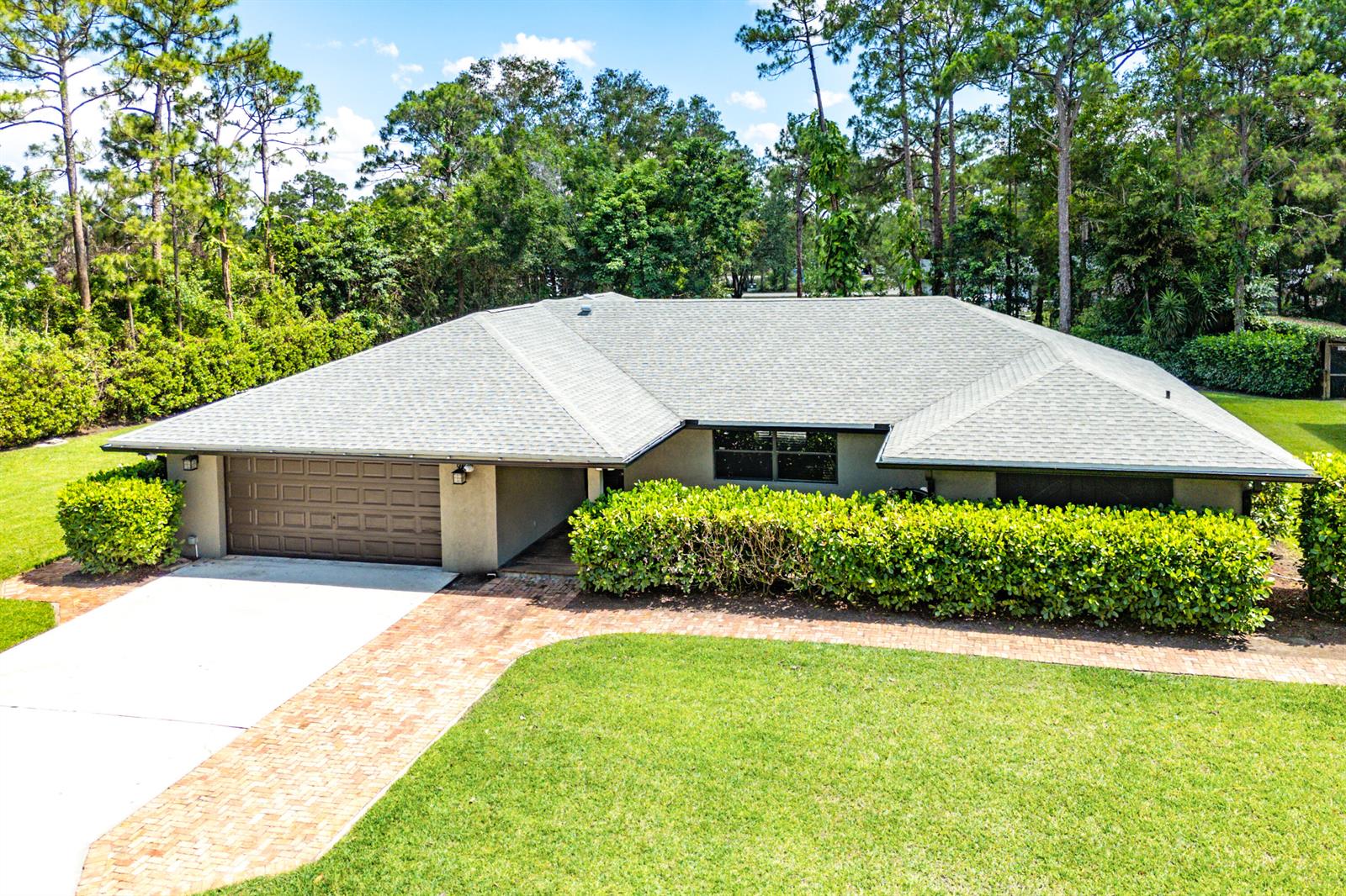A single-story house with a gray roof, brown garage door, and a brick walkway — 13530 N 59th Ct Court N, FL 33411, FL