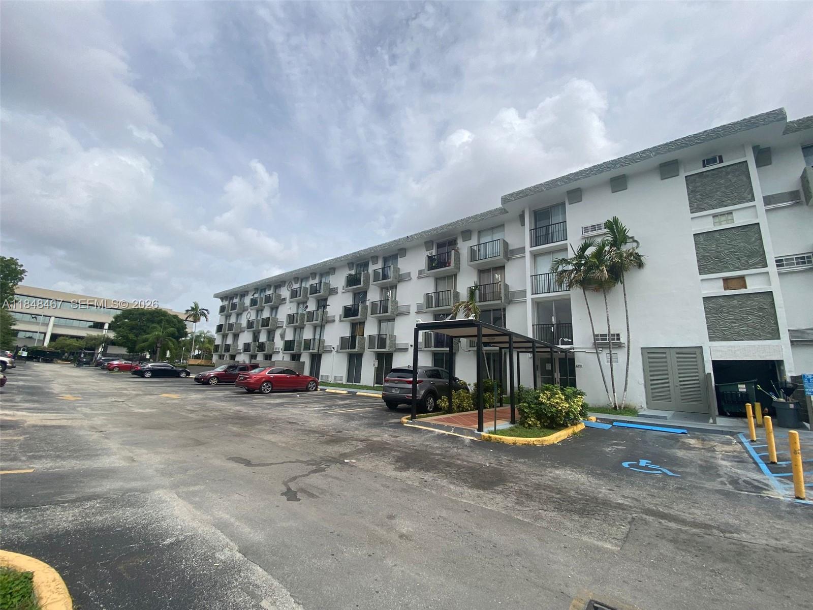 A multi-story apartment building with balconies and a parking lot in the foreground — 16450 NW 2nd Ave # 404, Miami FL 33169, MIAMI, FL