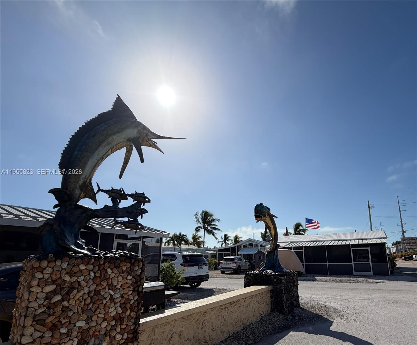 Two bronze fish sculptures stand on stone pedestals at the entrance to a mobile home park — 1361 Overseas Hwy G13, Marathon FL 33050, MARATHON, FL