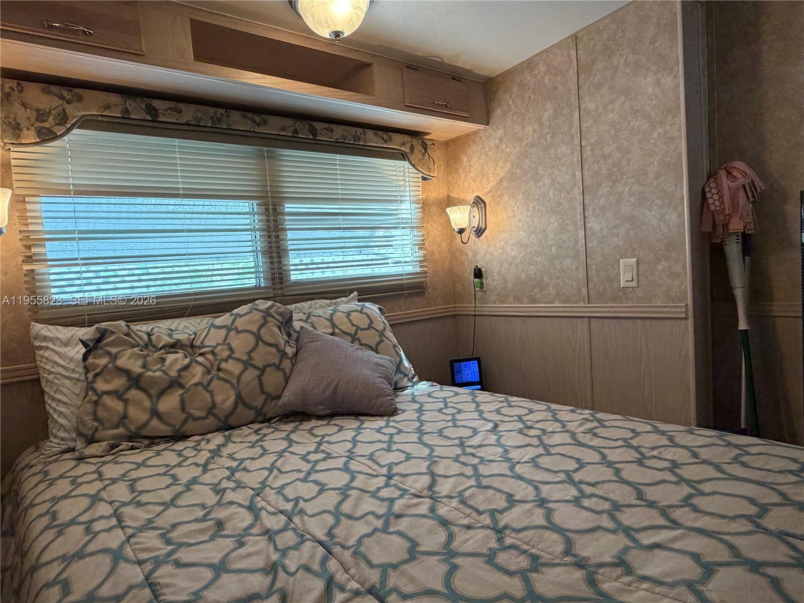 A bedroom in a recreational vehicle features a bed with patterned bedding and window blinds — 1361 Overseas Hwy G13, Marathon FL 33050, MARATHON, FL