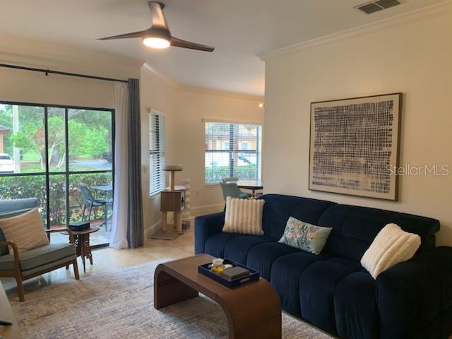 A living room features a dark blue sofa, a wooden coffee table, and tile flooring — 2200 TUSCANY TRACE UNIT 1714, PALM HARBOR, FL