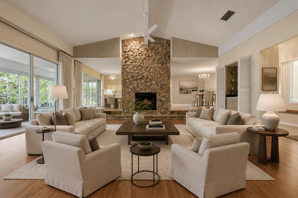 A living room features a large stone fireplace, neutral furniture, and a vaulted ceiling — 1352 ERROL PARKWAY, APOPKA, FL