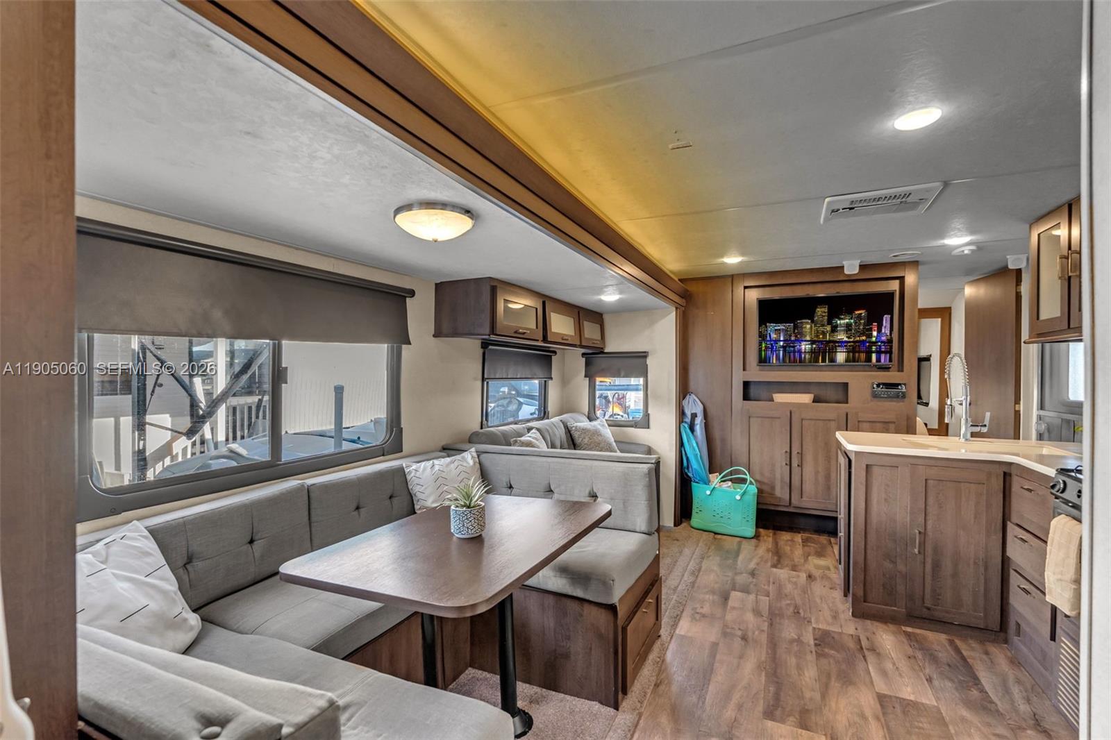 The interior of a recreational vehicle features a dining booth, kitchen area, and television — 325 Calusa St 44, Key Largo FL 33037, KEY LARGO, FL