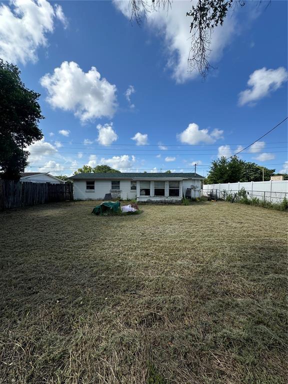 A single-story house with a large, grassy backyard under a blue sky with clouds — 4923 STATE ROAD 54, NEW PORT RICHEY, FL