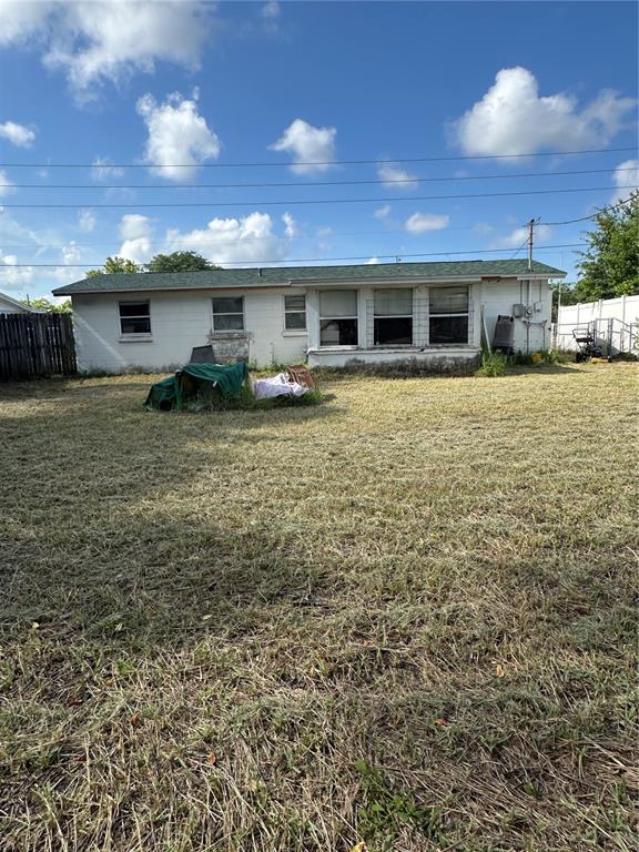 The exterior of a single-story white house with a green roof sits on a lawn — 4923 STATE ROAD 54, NEW PORT RICHEY, FL