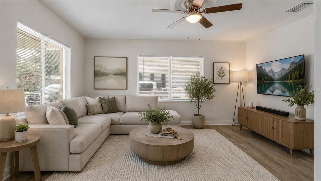 A living room features a beige sectional sofa, a round wooden coffee table, and a television — 1213 E 24TH AVENUE, TAMPA, FL