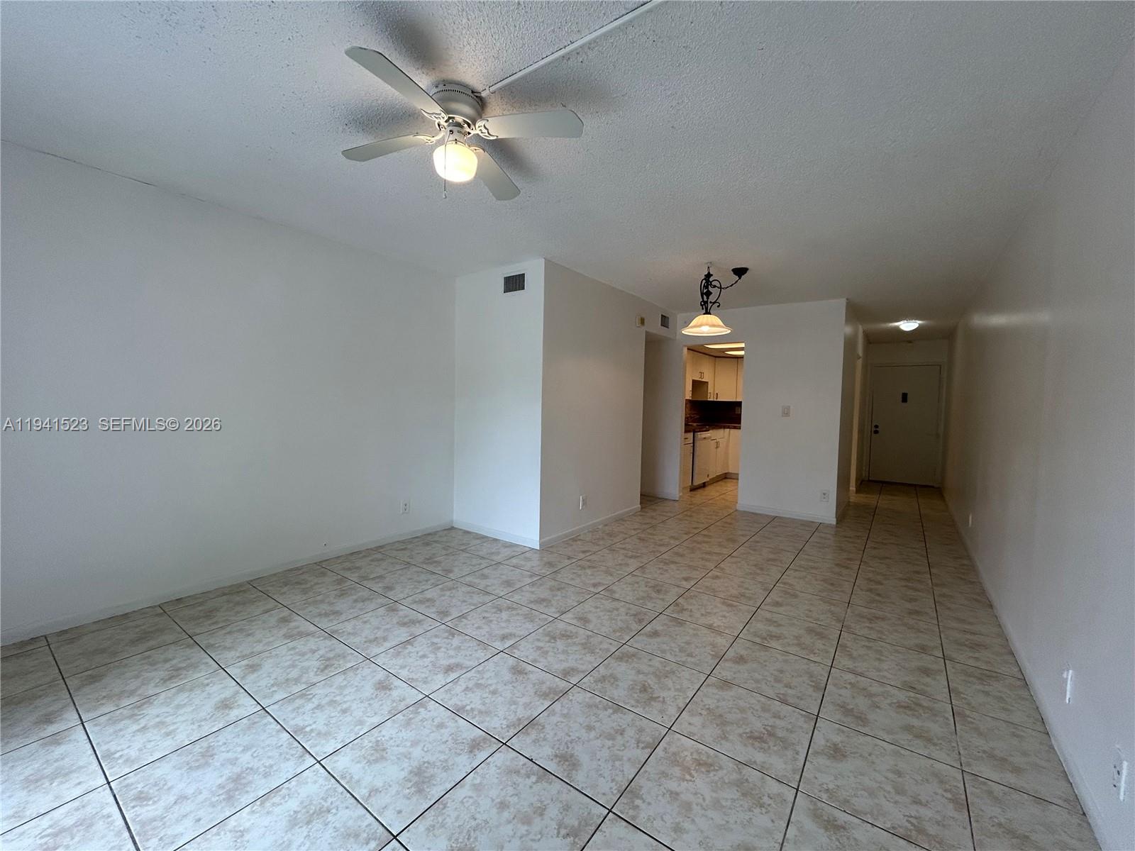 An open-concept living area features white walls, a ceiling fan, and light-colored tiled flooring — 4354 NW 9th Ave # 1C, Deerfield Beach FL 33064, DEERFIELD BEACH, FL