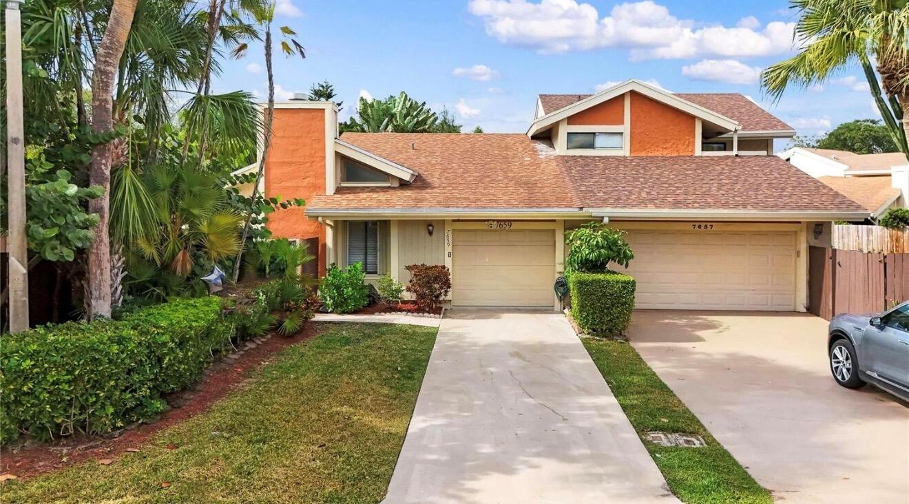A two-story house with an orange stucco chimney, two garage doors, and a concrete driveway — 7659 Sierra Terrace W, Boca Raton FL 33433, BOCA RATON, FL