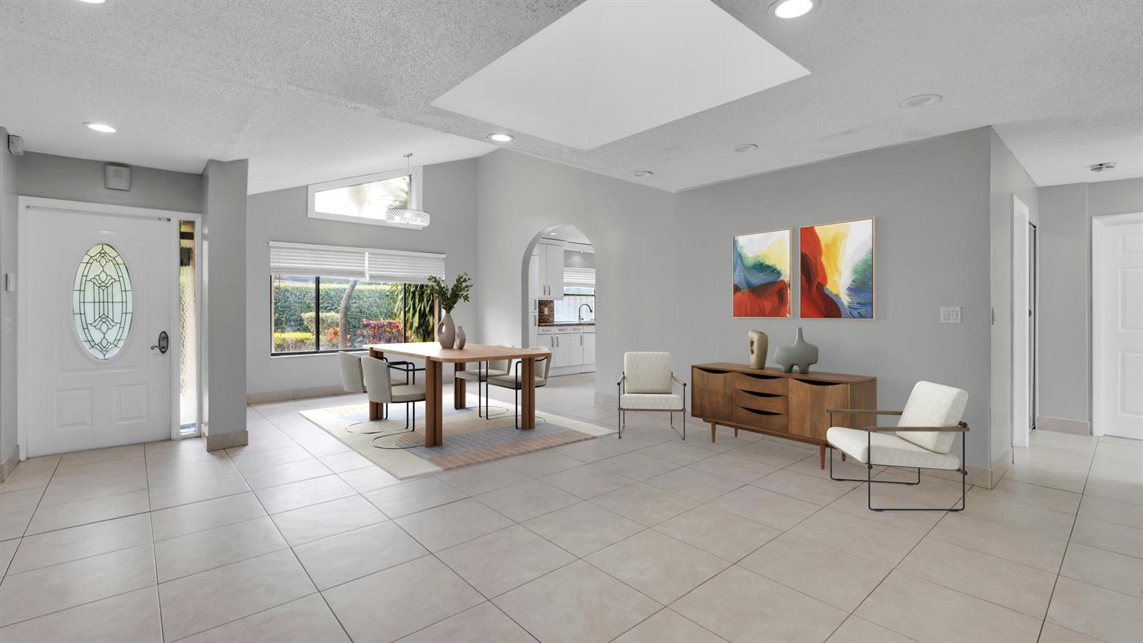 A dining area and living space feature light tile floors, gray walls, and a skylight — 7659 Sierra Terrace W, Boca Raton FL 33433, BOCA RATON, FL