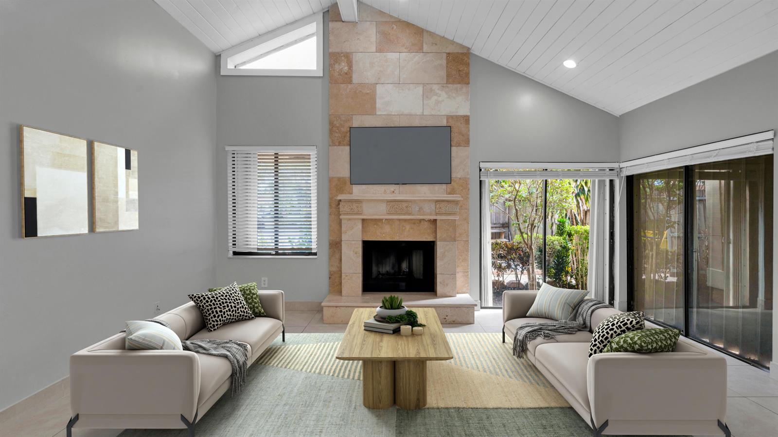 A living room features a vaulted ceiling, a stone fireplace with a television, and two sofas — 7659 Sierra Terrace W, Boca Raton FL 33433, BOCA RATON, FL