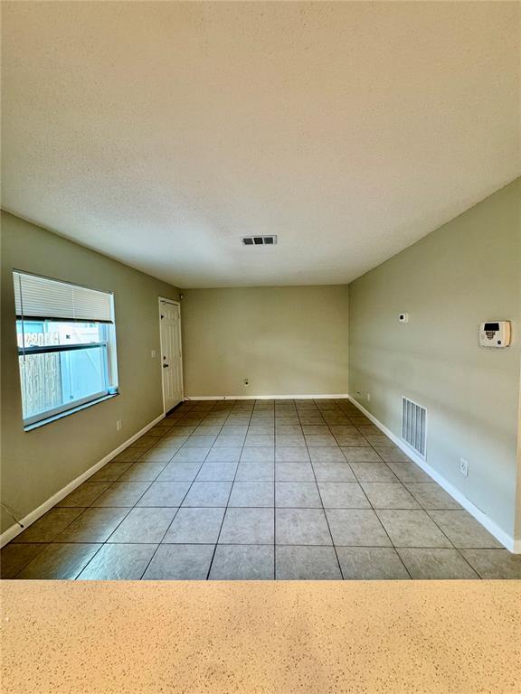 An empty room with light-colored walls, tile flooring, a window, and a white door — 2564 42ND AVENUE N, ST PETERSBURG, FL