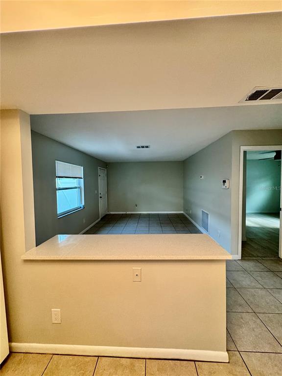 A kitchen island with a light countertop overlooks a living area with tiled floors — 2564 42ND AVENUE N, ST PETERSBURG, FL